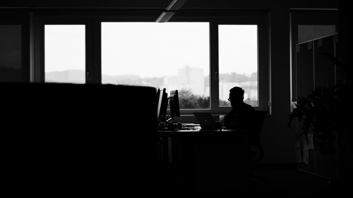 男性が暗い部屋で作業をしている写真